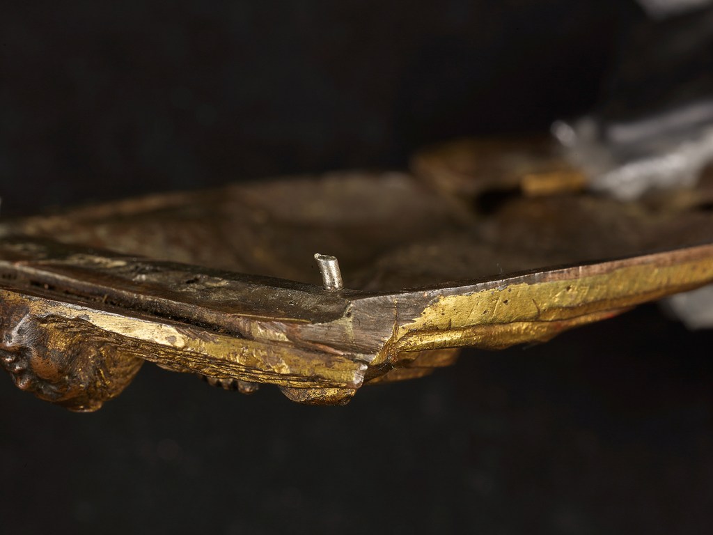 Fig. 05: Reverse of the Virgin-Child applique showing one of two silver rivets added along its base for mounting onto its later pax frame (Kollenburg Antiquairs)